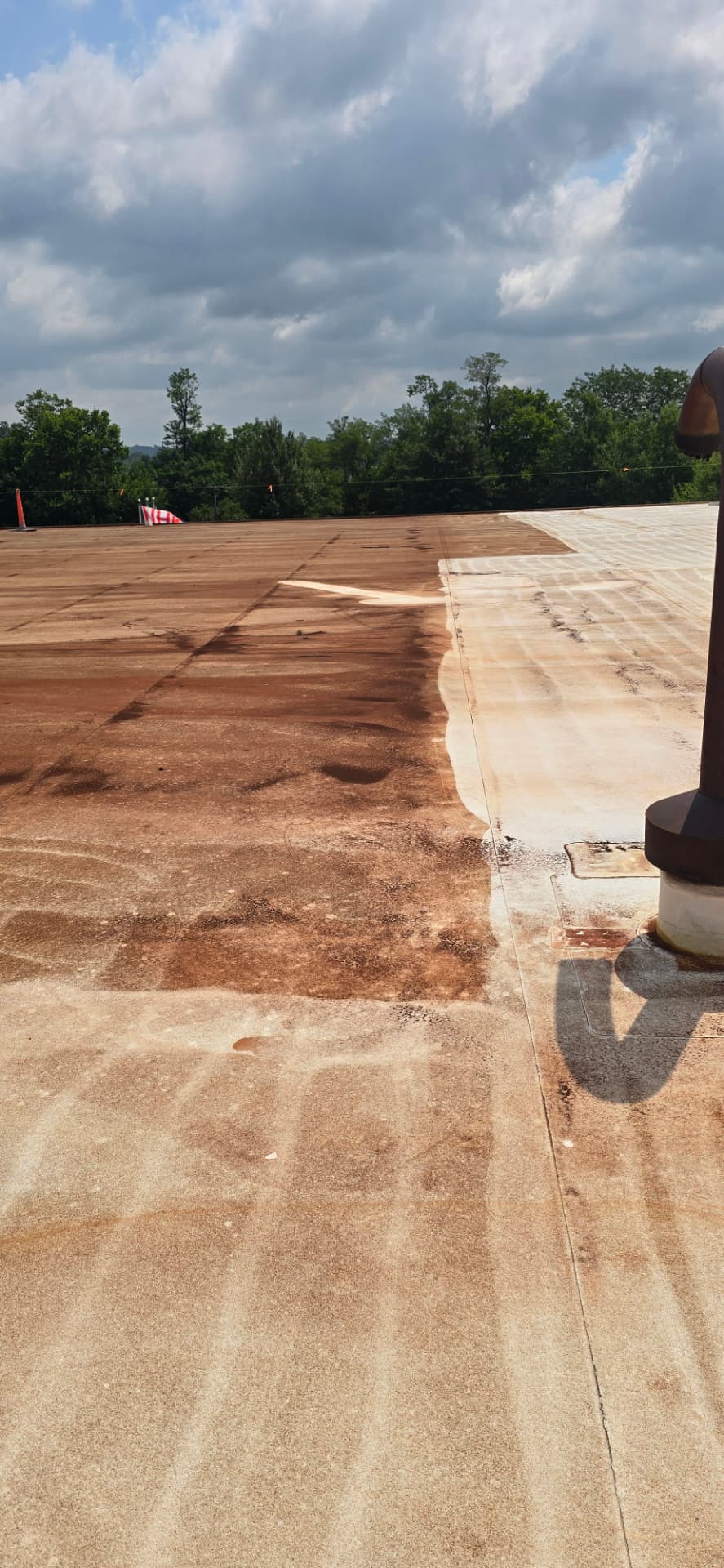 Commercial roofing crew cleaning and preparing an aged flat roof before restoration coating in Bowling Green, Kentucky